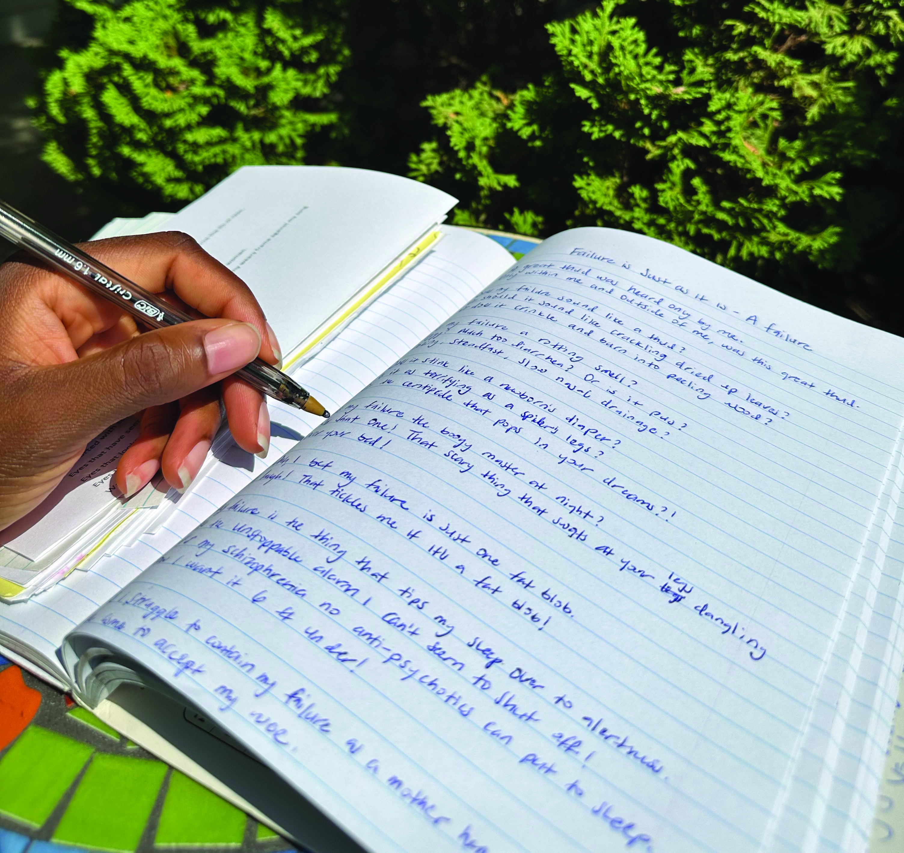 Closeup of Amarachi writing in her notebook.
