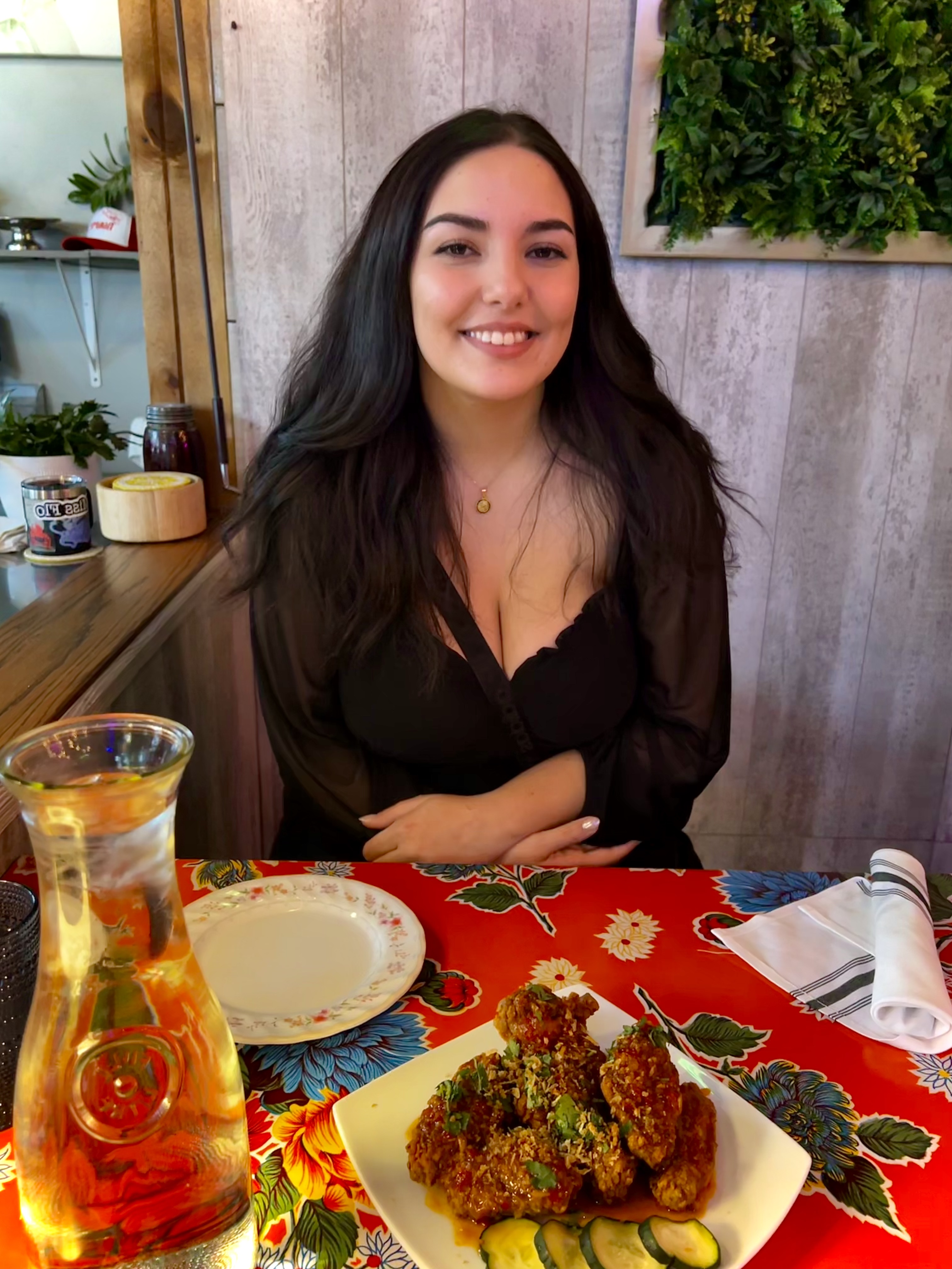 Petra Algadi at a restaurant with a plate of food and water on the table. 
