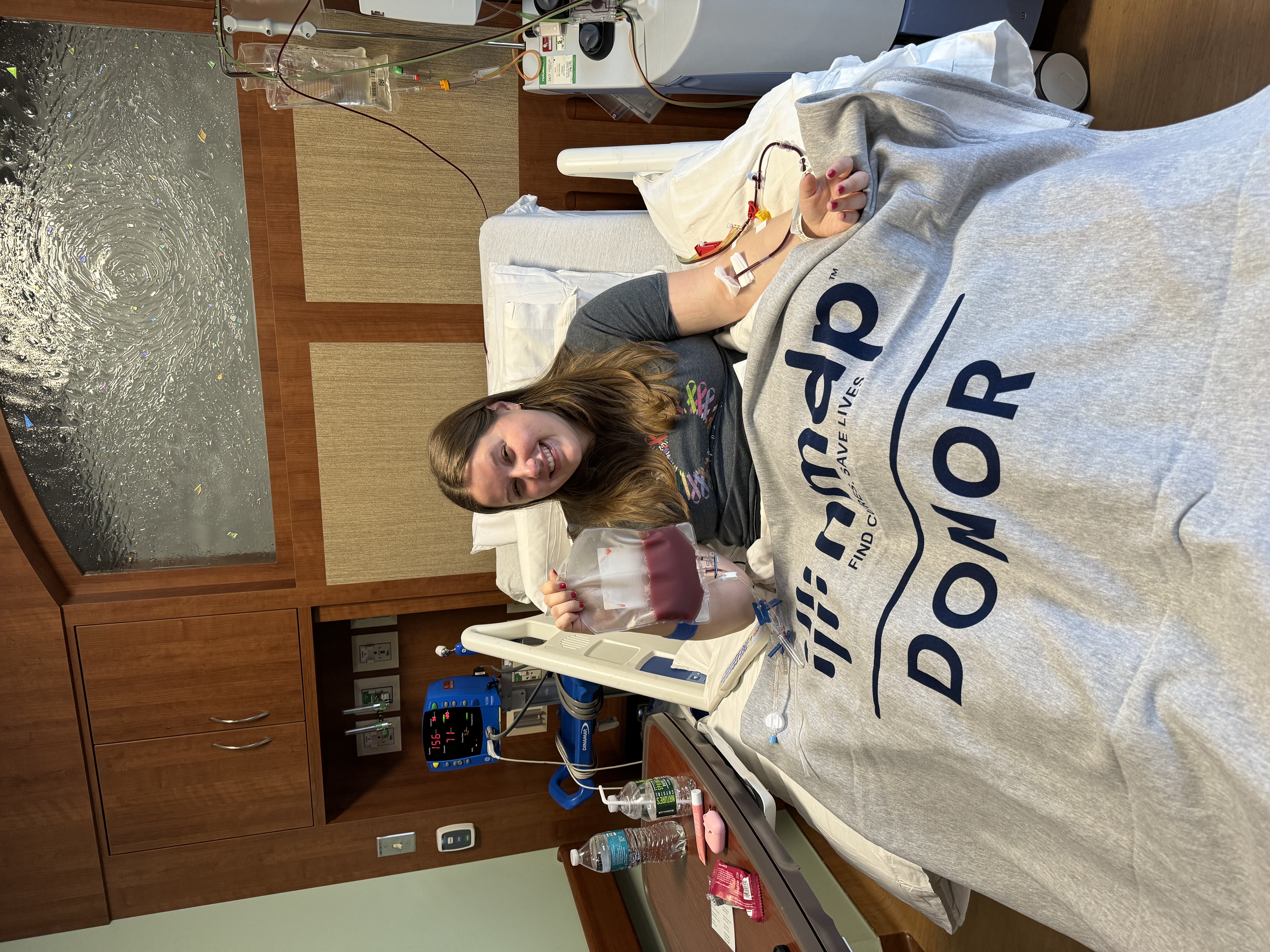 Kailyn Dewey in a hospital bed giving blood