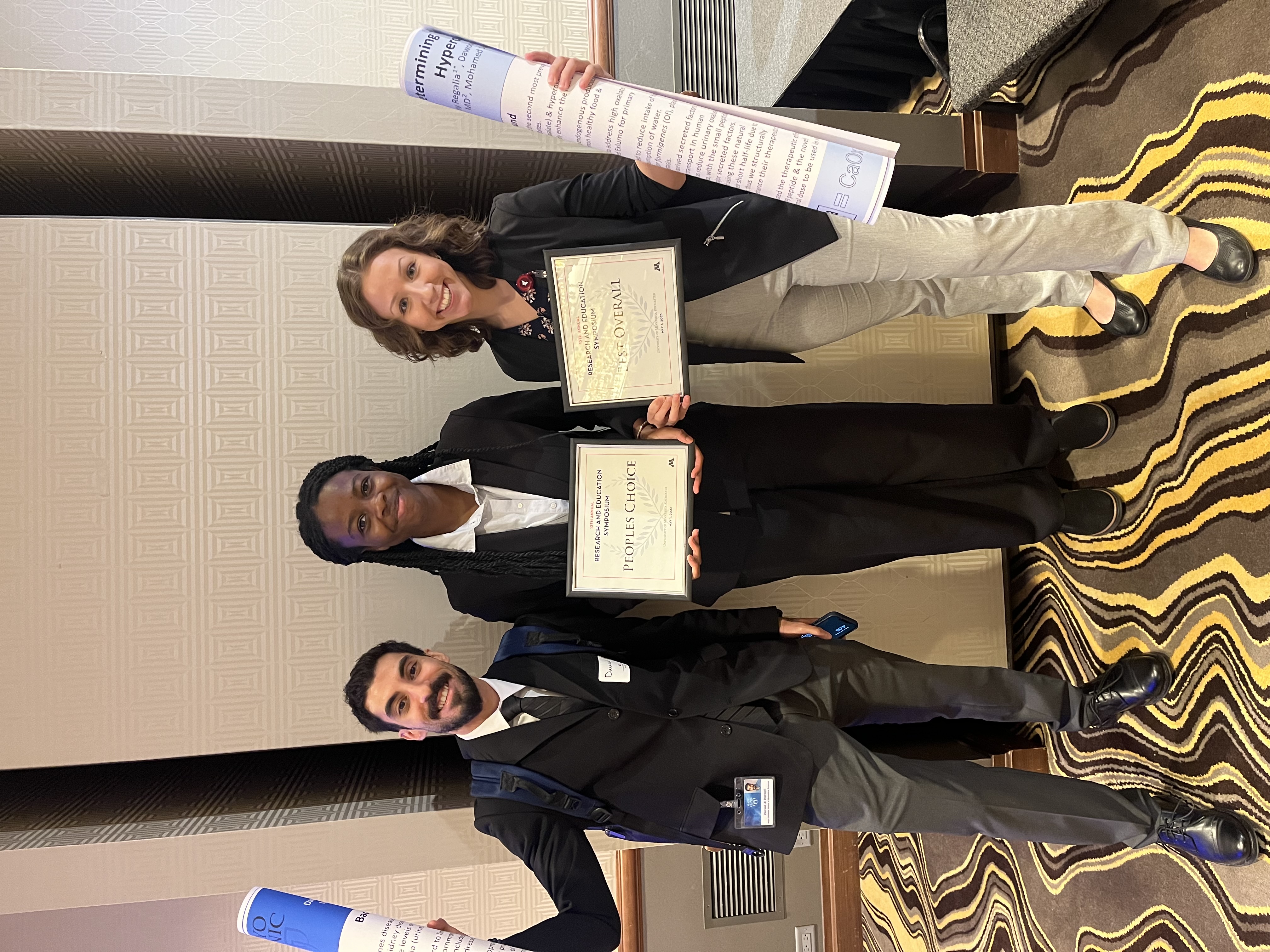 Three UMR students holding plaque and posters after winning People'c Choice Award