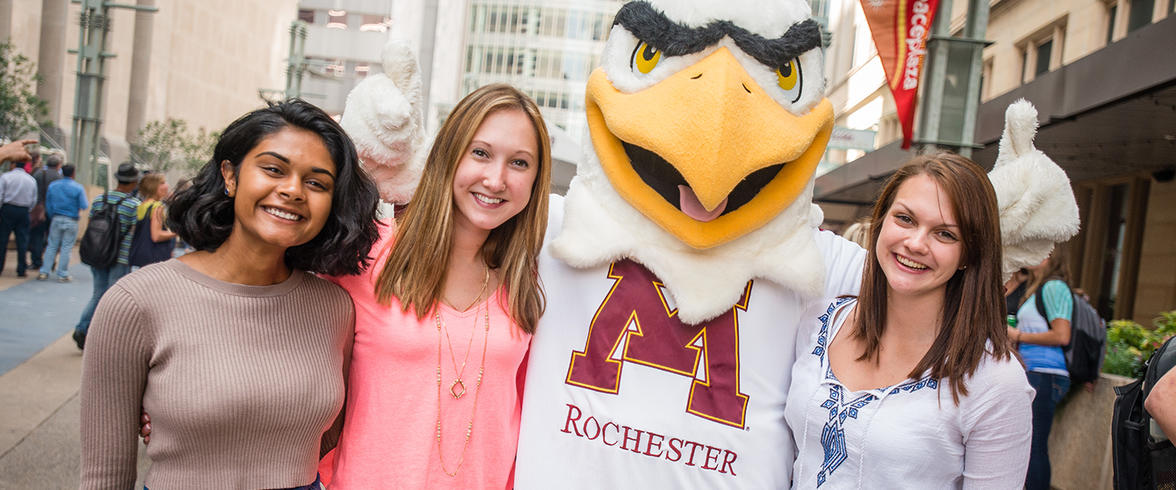 UMR student smiling with university mascot Rockie the raptor