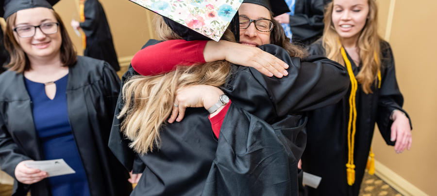 Graduate being hugged