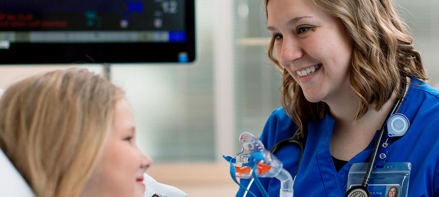 University of Minnesota Rochester Respiratory Care student describes medical equipment to a child patient.
